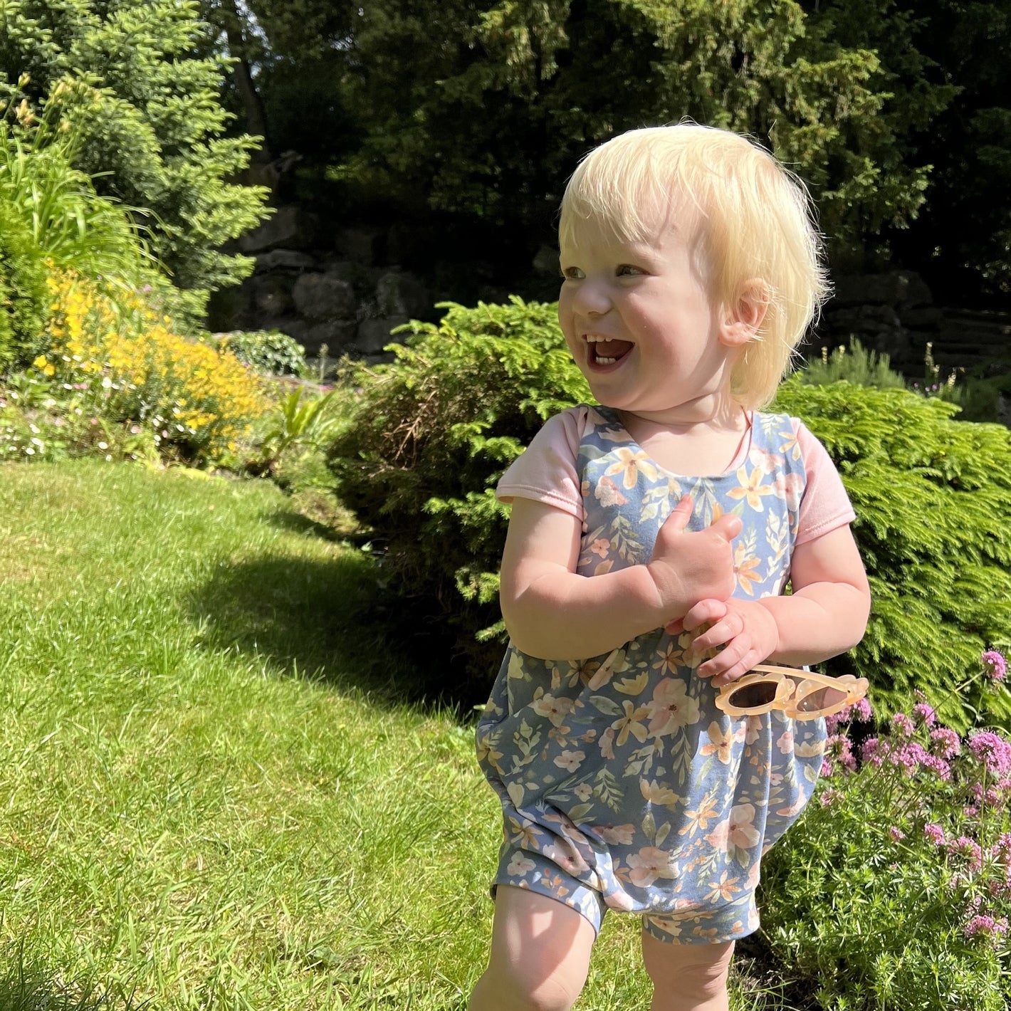 Adorable girl in handmade summer romper in Gatton Park gardens